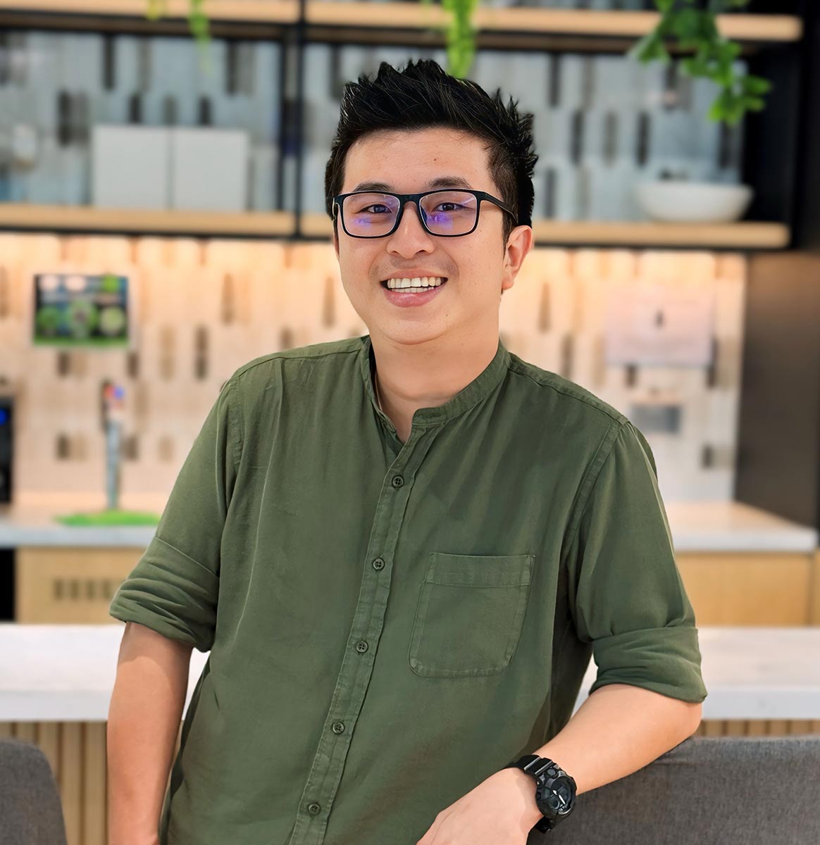Kon Shi Wang, in green polo-tee and blue jeans, portrait-view.